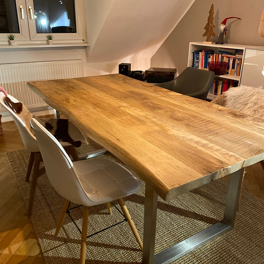 Mangoholztisch mit Baumkante und Stahl-Gestell in einem Wohnzimmer