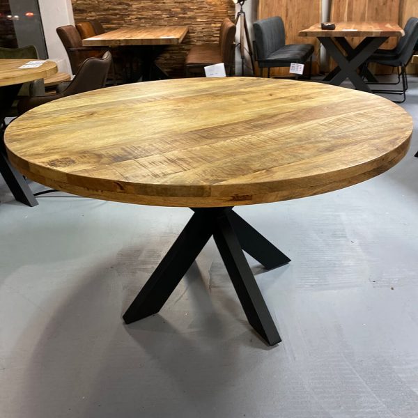 Runder Massivholztisch mit schwarzem Fuß in einem Möbelgeschäft